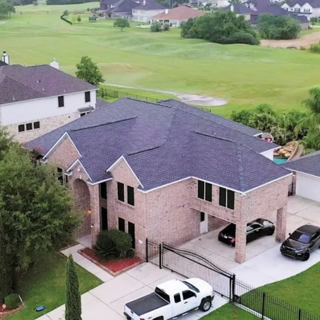 Residential home with dark blue roofing shingles and brick exterior.