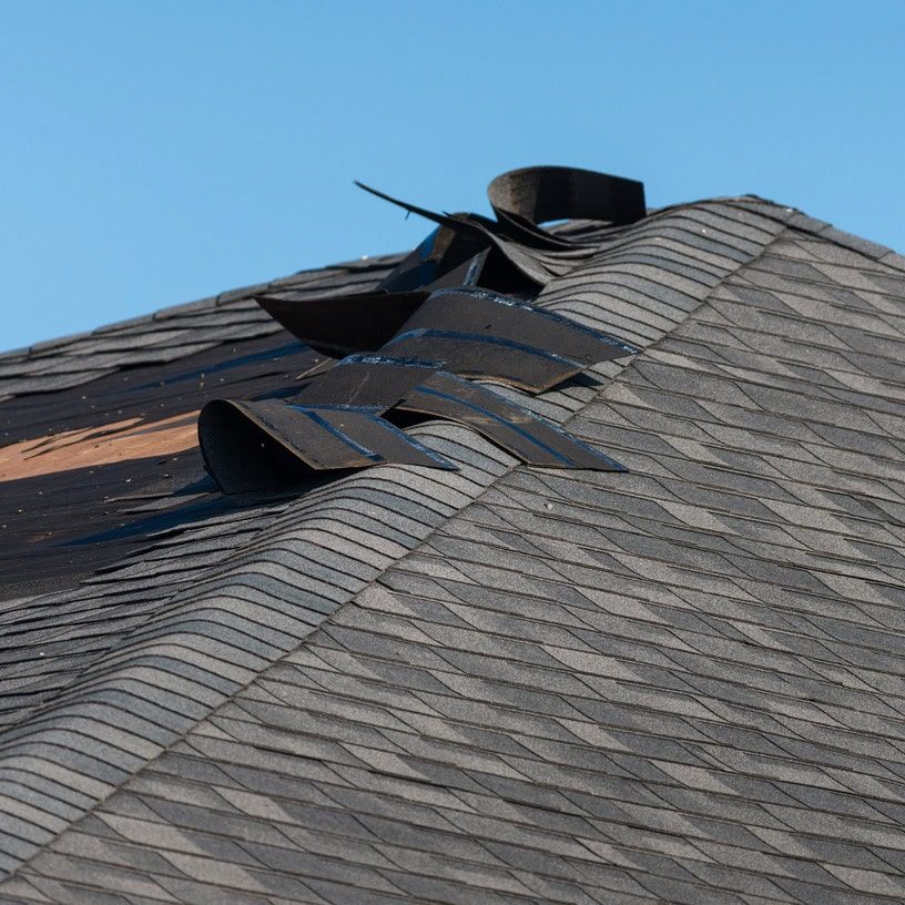 Damaged roof ventilation system with missing and broken vents on asphalt shingle roof.